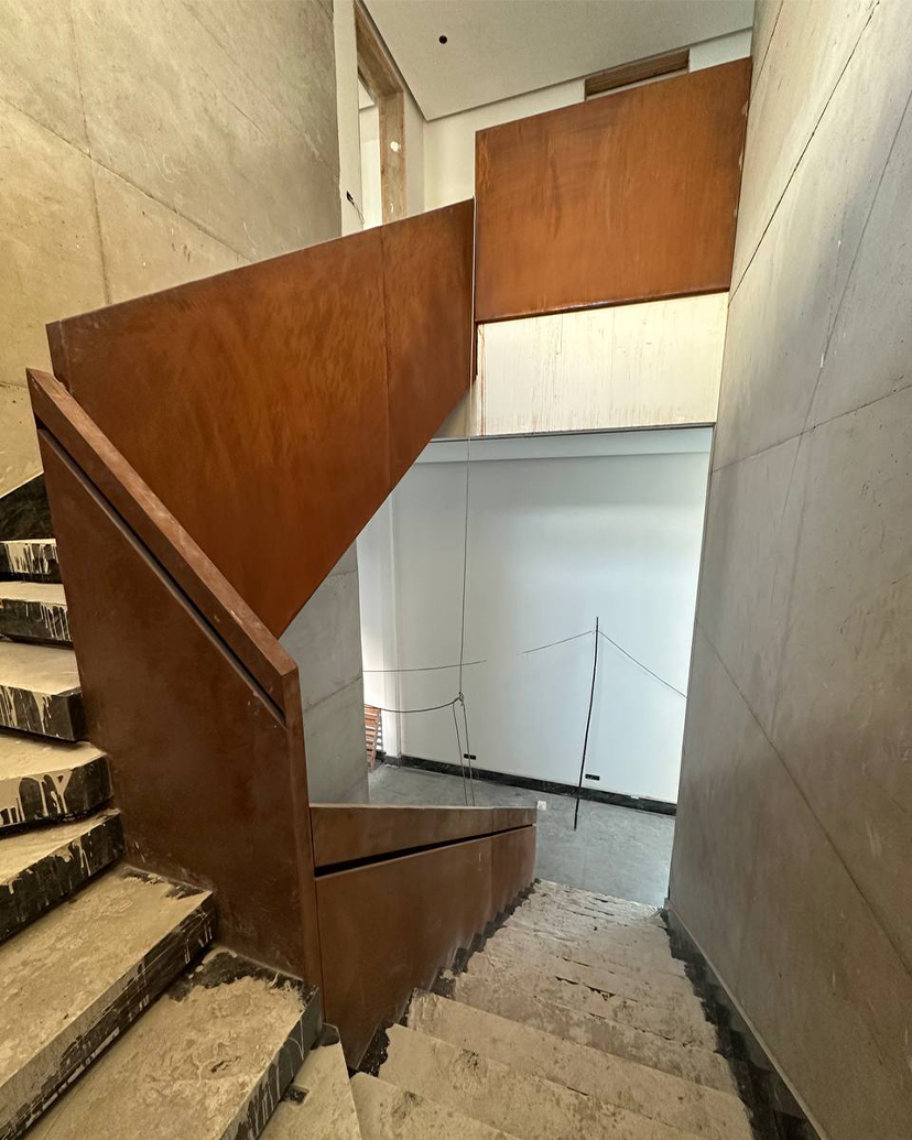 Escalier architectural sur mesure avec garde-corps en acier patiné dans une résidence contemporaine