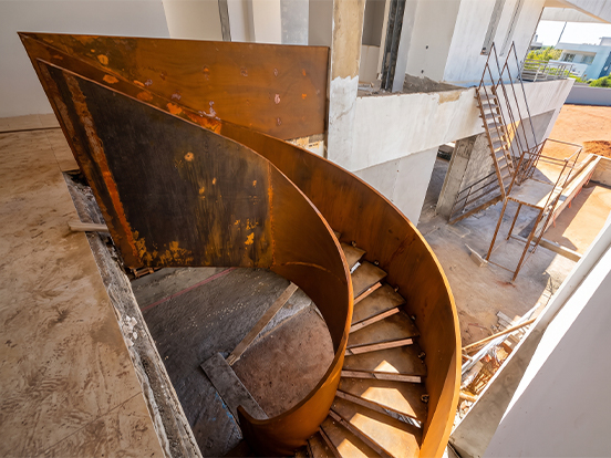 Structure d’escalier hélicoïdal en acier installée sur chantier avant les finitions