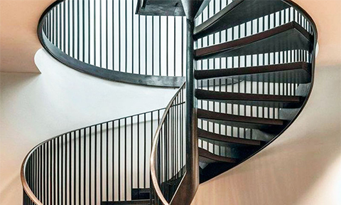 Escalier hélicoïdal métallique sur mesure avec marches en acier et garde-corps vertical