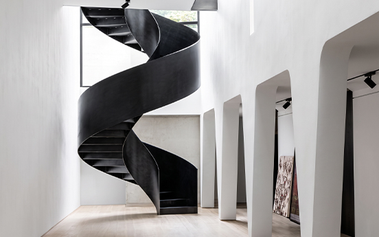 Grand escalier hélicoïdal noir en acier aux formes sculpturales