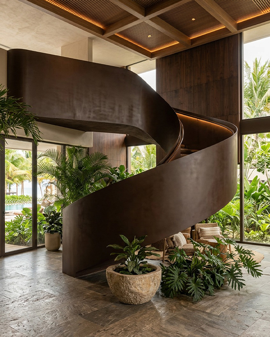 Escalier hélicoïdal métallique sur mesure aux formes sculpturales dans un intérieur contemporain