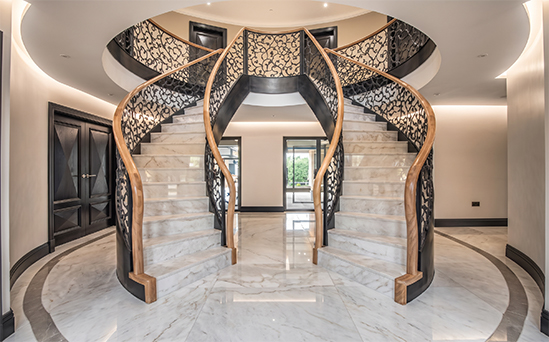 Escalier monumental à double volée avec marches en pierre et garde-corps décoratifs