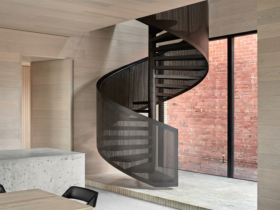 Escalier métallique noir sur mesure avec garde-corps perforé dans une villa contemporaine