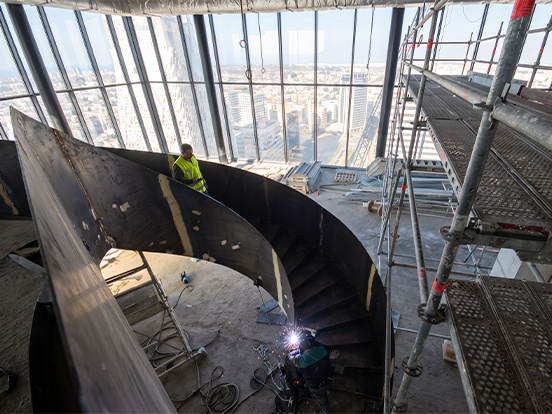 Installation sur chantier d’un grand escalier hélicoïdal métallique en acier